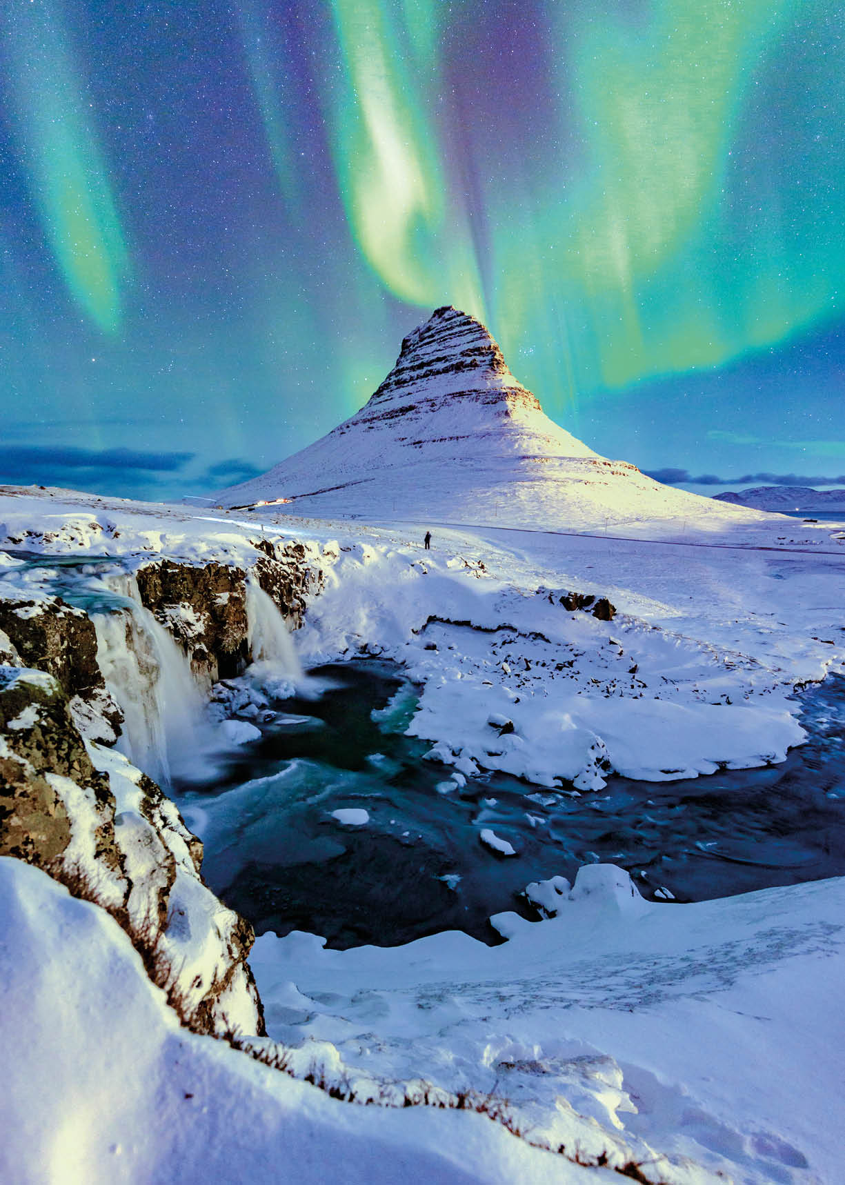 northern lights appear over Mount Kirkjufell in Iceland.