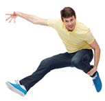 Mann mit freudigem Gesichtsausdruck springt mit nach hinten angwinkelten Beinen vor Freude in die Luft