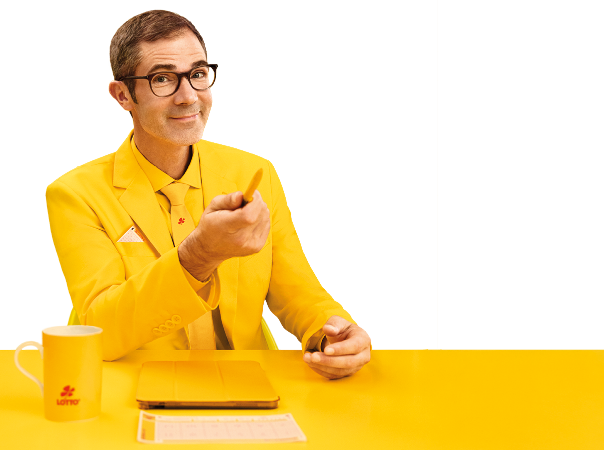 Das Bild zeigt einen sitzenden Mann vor einem einfarbig gelben Hintergrund. Er tr gt ein komplett gelbes Outfit, bestehend aus Sakko, Hemd und Krawatte, und sitzt an einem ebenfalls gelben Tisch.   Der Mann hat kurze dunkle Haare, tr gt eine Brille mit dunklem Rahmen und l chelt freundlich. Mit seiner rechten Hand zeigt er leicht nach vorne, als w rde er jemanden ansprechen oder etwas erkl ren. In der linken Hand h lt er einen Stift.    Auf dem Tisch vor ihm liegen ein gelbes Notizbuch oder Block sowie ein Lottoschein. Links steht eine gelbe Tasse mit einem kleinen roten LOTTO-Logo.    Die gesamte Szene ist farblich stark auf Gelb abgestimmt, wodurch ein auff lliger, moderner und leicht humorvoller Eindruck entsteht.