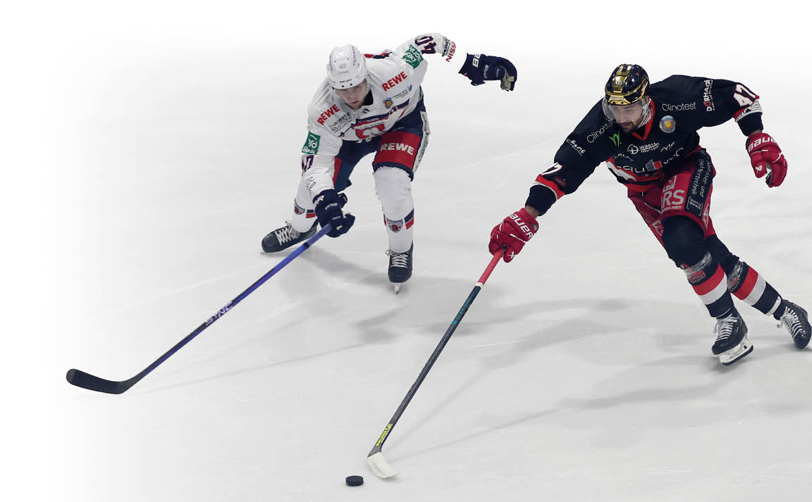 Zwei Eishockeyspieler liefern sich auf der Eisfl che ein Laufduell um den Puck: eine Person im schwarzen Trikot f hrt den Puck mit dem Schl ger, w hrend eine Person im wei en Trikot dicht dahinter versucht, den Puck zu erreichen. Beide tragen vollst ndige Schutzausr stung und Schlittschuhe auf einer hellen Eisfl che ohne sichtbaren Hintergrund.