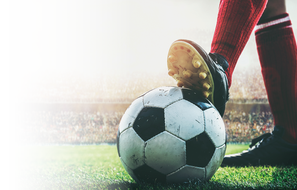 feet of soccer player tread on soccer ball for kick-off in the stadium