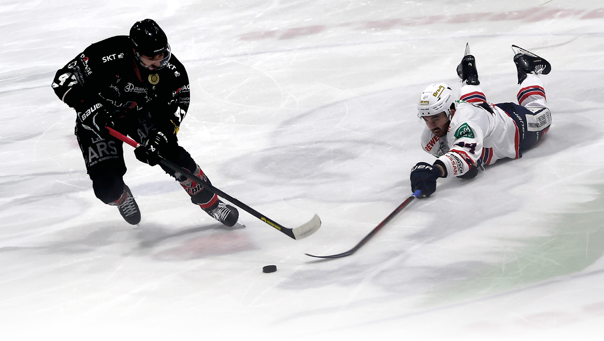 Zwei Eishockeyspieler in unterschiedlicher Ausr stung k mpfen auf dem Eis um den Puck, wobei einer liegt und der andere l uft. Beschreibung von KI generiert